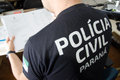 Policial civil lendo documentos