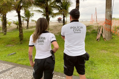 Dois policiais civis observam o litoral
