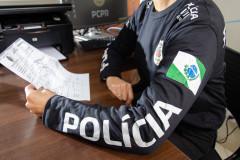 Policial civil com lendo documento