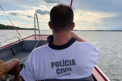 Policial civil de costas em barco