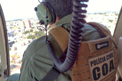 Policial civil sobrevoando cidade em helicoptero