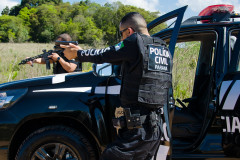 Dois policiais civis apontando armas em abordagem