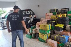 Policial civil observa pacotes da droga empilhados